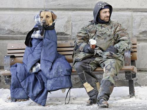 A man who identified himself as Mario sits with his dog, Spliff, as they bundle up against the -15C, 5F temperatures as he panhandles in downtown Montreal, Canada Thursday, March 10, 2005.(AP Photo/Ryan Remiorz)
